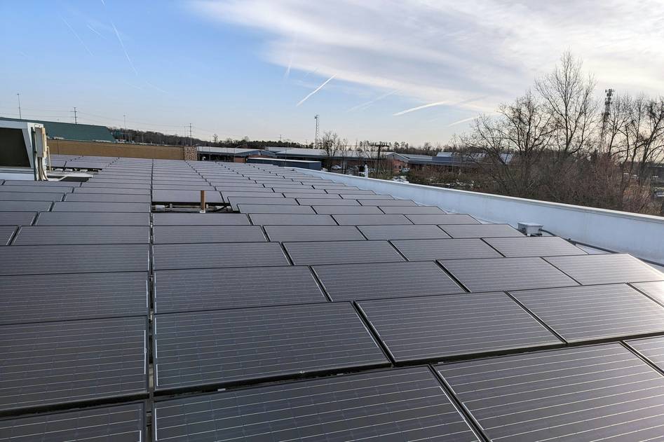 Modern rooftop installation of sleek black monocrystalline solar panels under bright sunlight