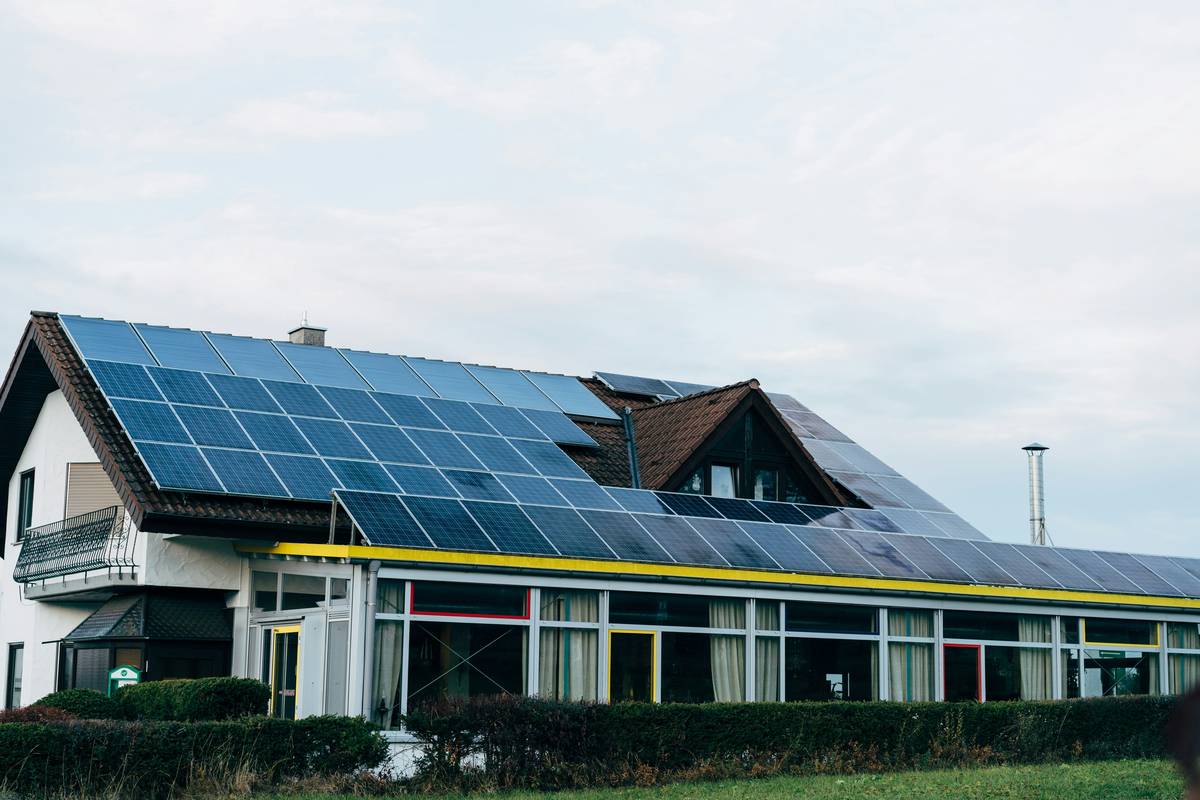Close-up of rooftop monocrystalline solar panels under sunlight with are solar panels green energy label visible